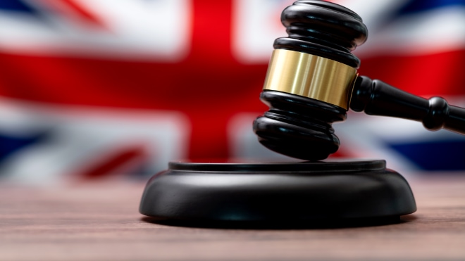 A judges gavel sat infront of a Union Jack flag.